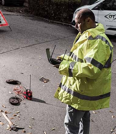 Techniker während einer Rohrbruchsuche im öffentlichen Versorgungsnetzes. Mit Hilfe von Korrelater und Leckspürtechnik kann die Reparaturkosten erheblich verringert werden.